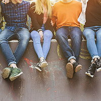 Summer holidays and teenage concept - group of smiling teenagers with skateboard hanging out outside. KESS erziehen - Abenteuer Pubertät